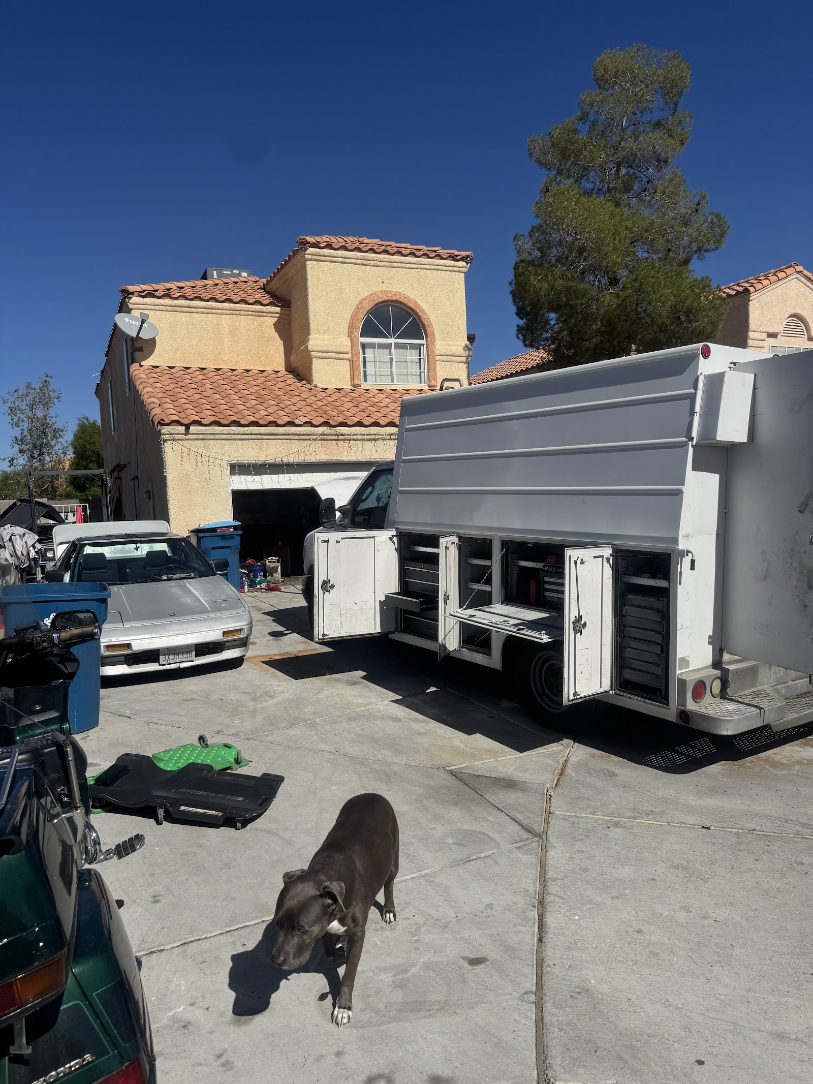 Mobile mechanic service utility truck with open tool compartments in a driveway